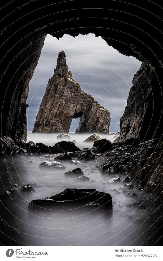 From cave view of rocky rough formations peak hole sharp grotto stiff gorge highland cliff mountain scenic uneven seashore stone geology seacoast scenery mist