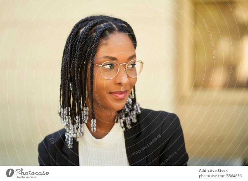 Smiling stylish African American woman standing against blurred background style businesswoman confident outfit building urban modern smile positive