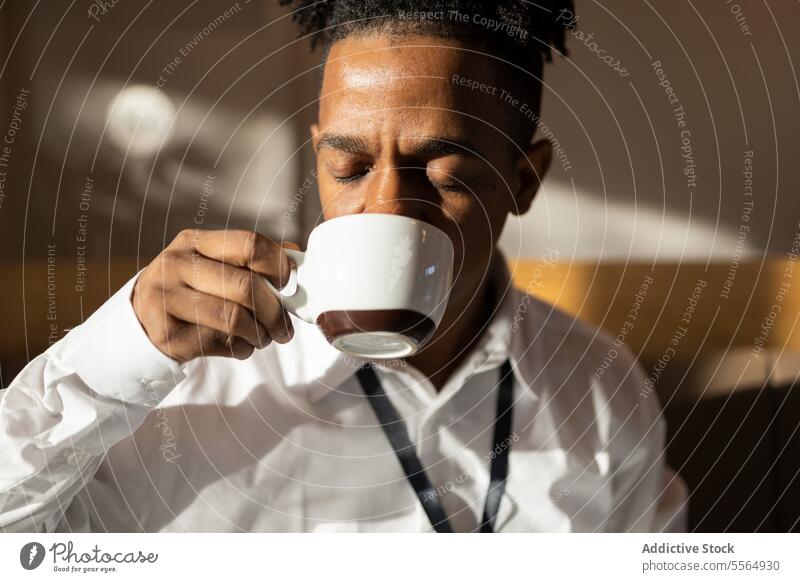 Crop headshot of black man drinking hot beverage credit card coffee cup cafe hot drink pensive portrait calm african american male coffee break guy ethnic mug