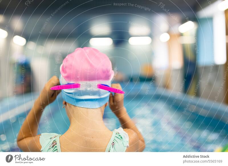 Preschooler girl ready for indoor swimming session pool swimmer preschooler cap pink goggles blue anticipation water training lesson activity sport edge depth