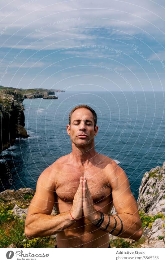 Man meditating by the ocean man sea tranquility prayer mature close-up eyes closed calm serenity concentration relaxation outdoors coast wellness health nature