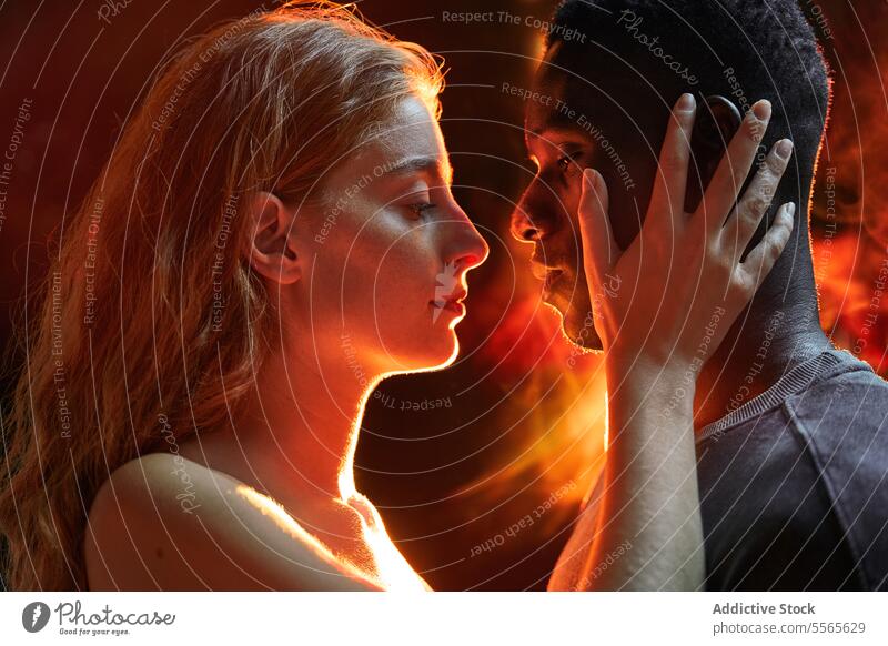 Intimate multiracial couple gaze close-up intimate eyes fiery ambiance connection love emotion passion warmth touch woman disco profile light redhead shadow
