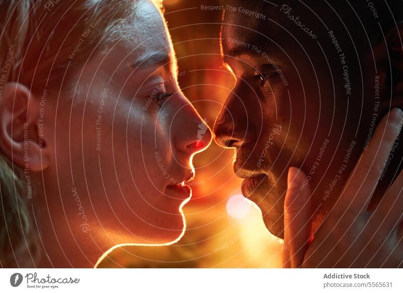 Intimate multiracial couple gaze close-up intimate eyes fiery ambiance connection love emotion passion warmth touch woman profile light redhead shadow