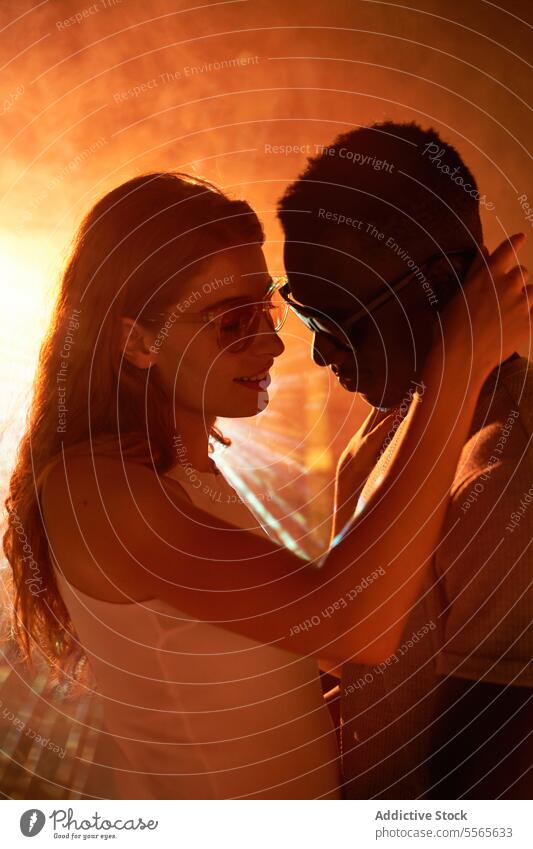 Multiracial couple at the disco multiracial close-up intimate gaze eyes fiery ambiance connection love emotion passion warmth touch woman light redhead shadow