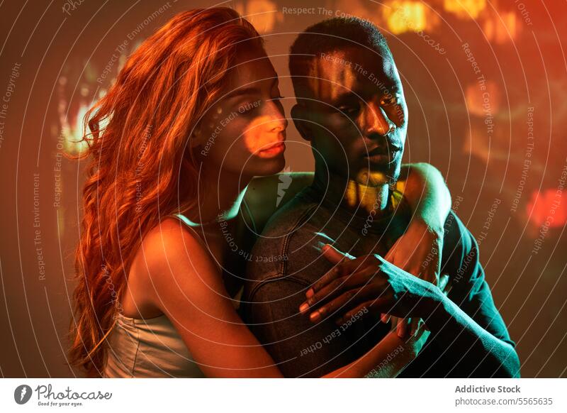 Multiracial couple at the disco multiracial close-up intimate gaze eyes fiery ambiance connection love emotion passion warmth black touch hug woman