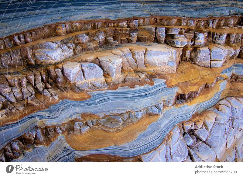 A background of blue and yellow rocks texture grey water natural costa asturias coastal nature landscape art artwork scenery sea ocean waves beach rocky serene