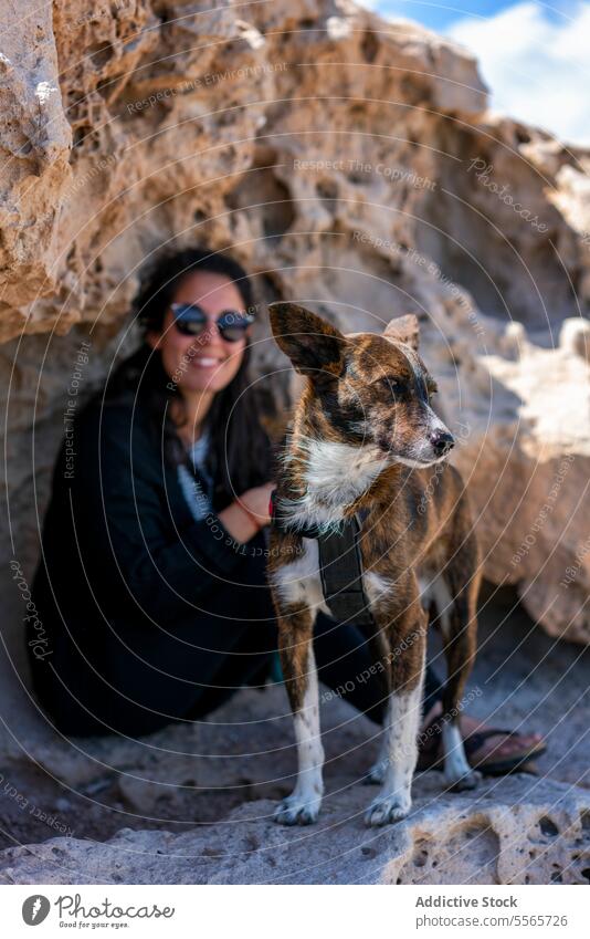 Woman with her dog next to some rocks woman pets nature outdoors mammal adult day one person friendship togetherness young adult rock climbing sitting sun