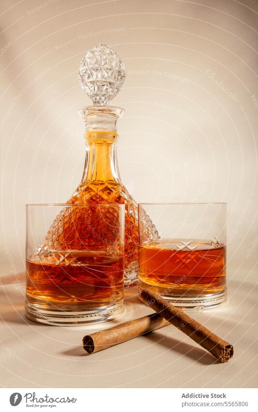 Glasses of whiskey on table near decanter and cinnamon glass cup cold drink alcohol crystal container beverage liquid cool composition party luxury elegant