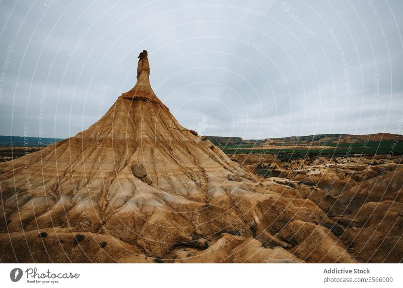A large rock formation in the middle of a desert bardenas reales navarra arid dry sand dunes landscape geology erosion stone nature wilderness barren isolated