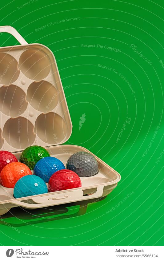 Set of colorful golf balls in box with golf club game sport plastic equipment play activity bright surface object set design container recreation isolated blue