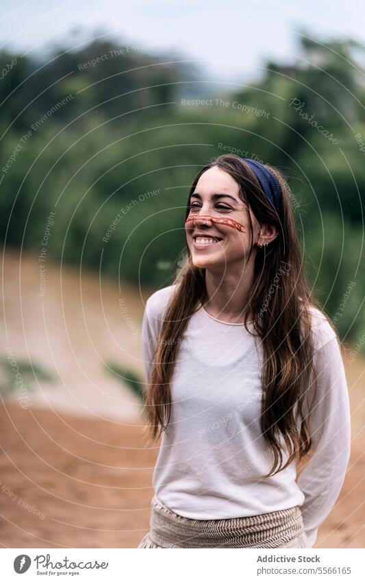Smiling young female laughing while standing against blurred background woman paint smile nature forest happy cheerful green traditional casual glad positive