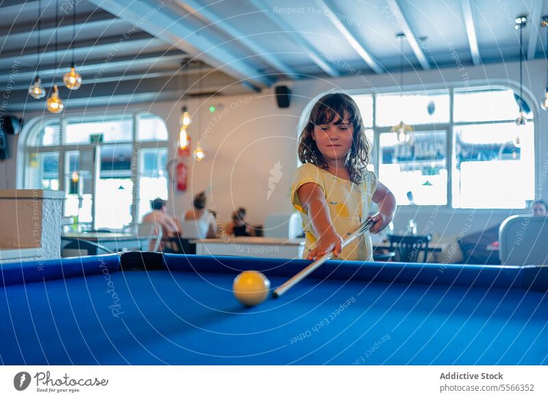 Kid playing billiards game confident focus concentrate pool cue shot ball prepare challenge determine player recreation table goal entertain strategy skill
