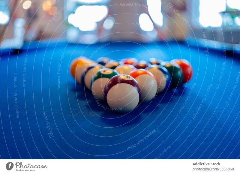 Closeup of billiard balls on pool table against anonymous people leisure recreational pyramid pub play indoors game sport snooker colorful different number blue