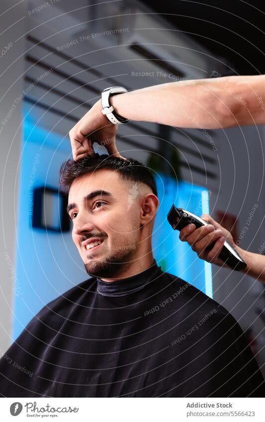 Smiling client during nape trim in modern salon Client barber smiling male temple watch wrist man caucasian trimmer smile styling professional barbershop