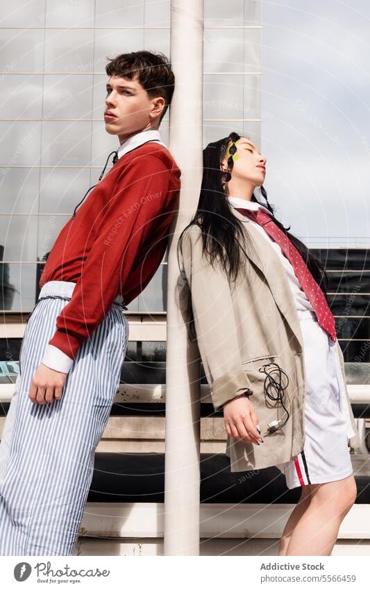Young woman and young man posing in urban setting with fashion style. Fashion Gen-Z work city pose confidence trendy backdrop male female makeup youth