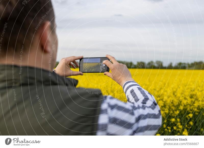 Mature man capturing nature's bloom through smartphone lens. capture flower field yellow photography outdoor spring beauty mature caucasian meadow landscape
