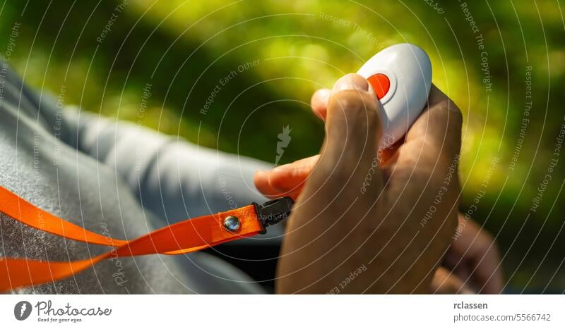 Senior Man Pressing Alarm Button For Emergency call in a park outside. hand medical alarm system emergency call alert button senior elderly panic help care