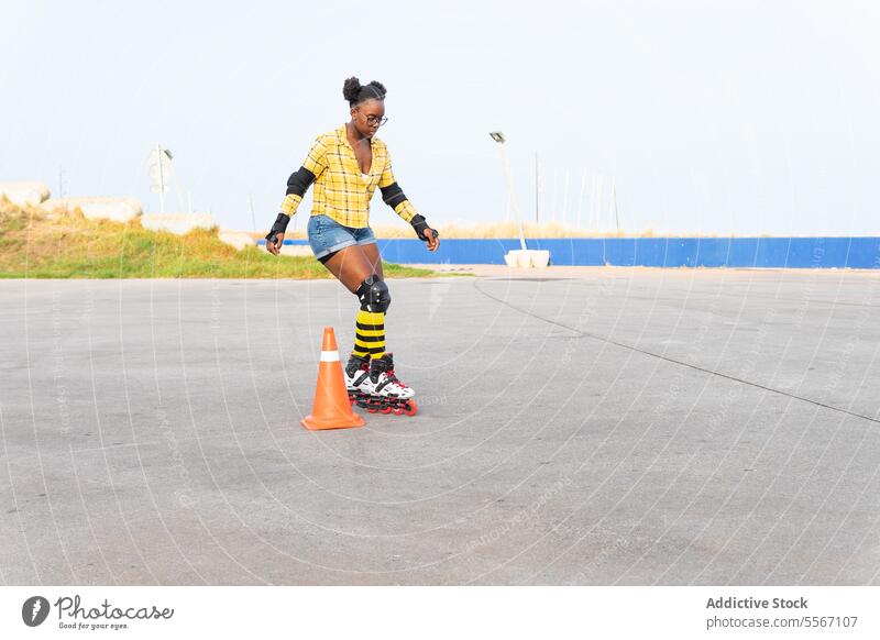 Woman Rollerskating By Cone While Practicing On Rink At Skate Park Skating Practice Learn Protection Casual Sky Yellow Sport Blade Leisure Weekend Activity