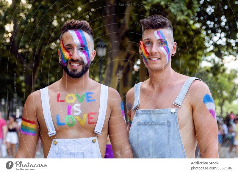 Two men in Rainbow pride man duo rainbow face paint LGBTQ celebration street portrait message love chest joyful vibrant color happy expression support unity