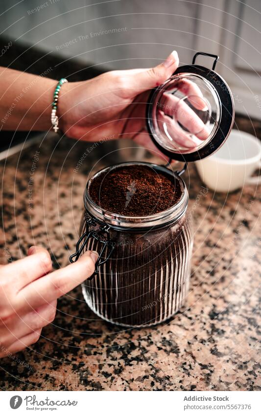 Opening coffee jar hand ground texture granite countertop lid metal aromatic preparation home brew Italian close-up bean storage kitchen fresh container glass