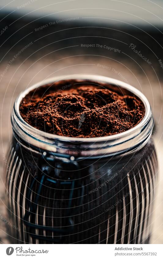 Ground coffee in ribbed jar ground texture depth glass Italian home preparation independent rich brown aromatic mottled background bean freshness container dark