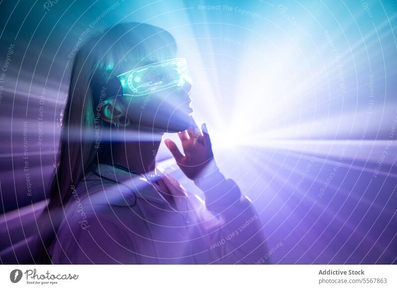 Woman in VR goggles touching face with lights woman vr glasses futuristic explore cyberspace studio shot imagine long hair bangs trendy style blonde headset