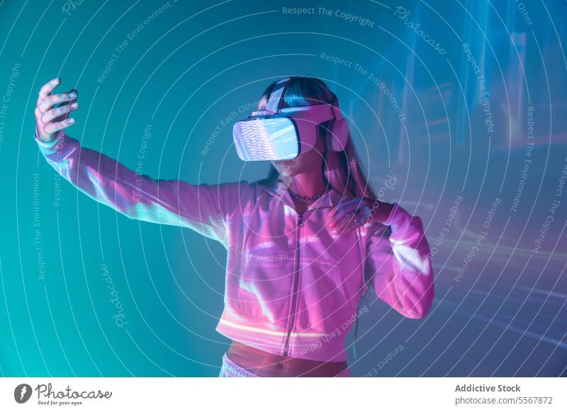 Anonymous woman in VR goggles exploring cyberspace on glowing lights vr explore virtual reality young headset simulator glasses augmented innovation play