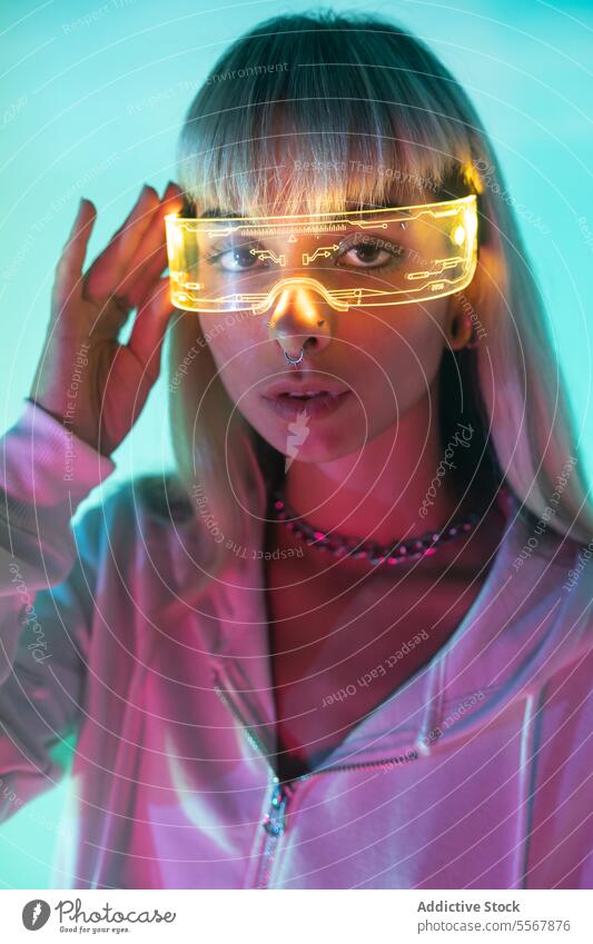 Woman wearing futuristic VR glasses woman young vr led virtual reality confident portrait goggles style modern light illuminate cool headset simulator augmented