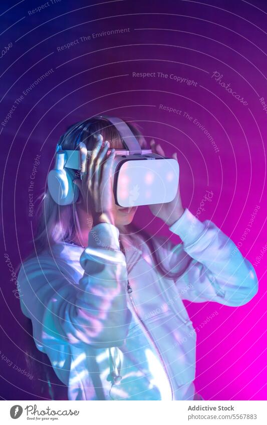 Anonymous woman in VR goggles exploring cyberspace on glowing lights vr explore virtual reality young headset simulator glasses augmented innovation play