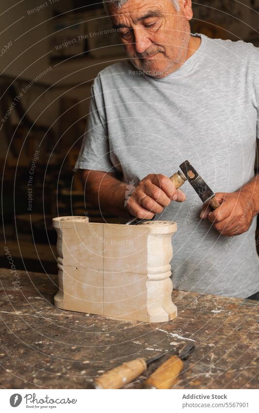 Carpenter chiseling wood in Toledo carpenter man workshop elderly carving skill craft tool hand workbench artisan manual male labor expertise design object