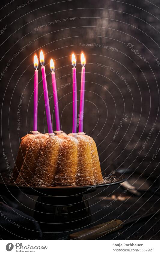 A bundt cake with five burning candles. Still life. Gugelhupf shoulder stand Birthday mood Dessert Cake baked Self-made Ready to serve cute Delicious Food
