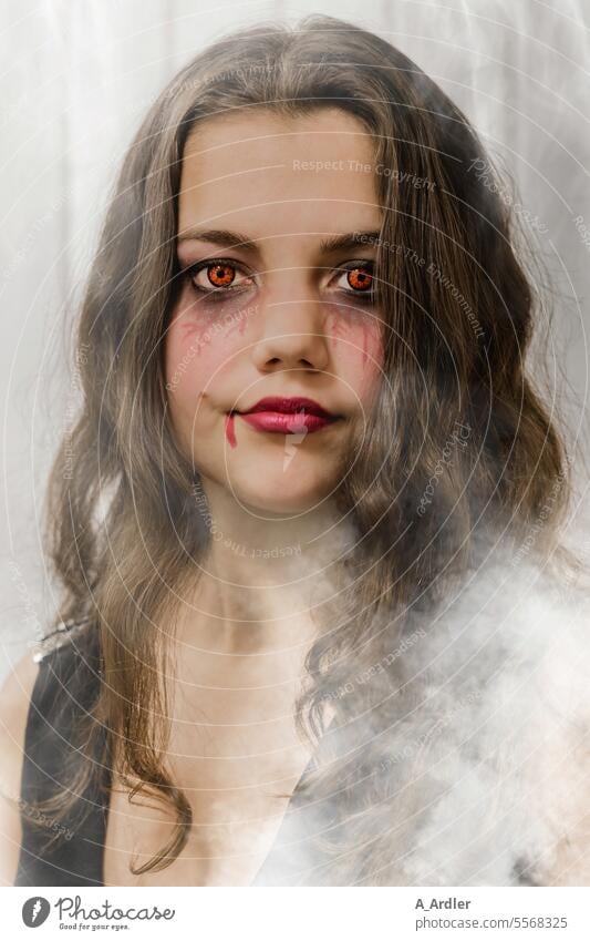 young woman in fog with long brown hair, Halloween make-up and creepy pupils Hallowe'en Pupil Woman Face Colour Cosmetics Make-up Eyes Glamor Beauty & Beauty