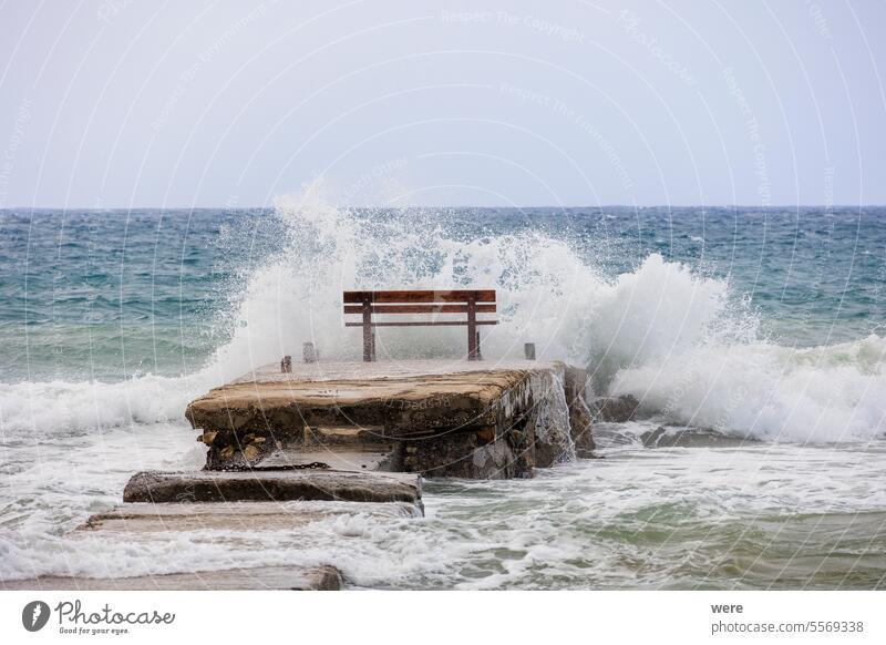 A resting bench in the middle of the waves on the island of Corfu near the town of Arillas under blue skies and heavy seas Beaches Byzantine churches Corfu Town