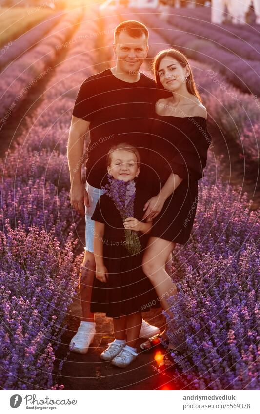 happy family day. young father, mother and child daughter are having fun together in the lavender field. happy couple with kid enjoy summer holiday vacation. family look
