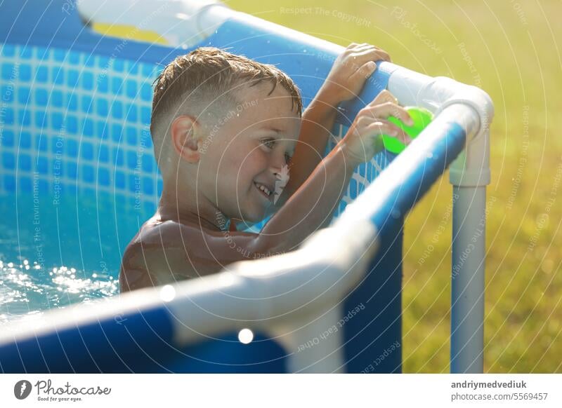 Portrait smiling boy is playing in swimming pool. Summer vacation or classes. Summertime and swimming activities for happy children on the pool fun kid summer