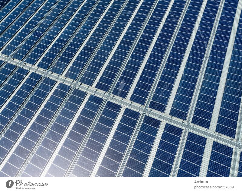 Aerial view of solar panels or photovoltaics on factory roof. Solar power for green energy. Sustainable renewable energy. Solar cell panels generate electricity from sun lights. Photovoltaics or PV.