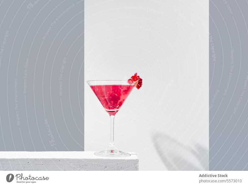 Elegant pomegranate cocktail presentation glass red garnish backdrop shadow gray vibrant beverage drink elegant decorative topping silhouette minimalistic