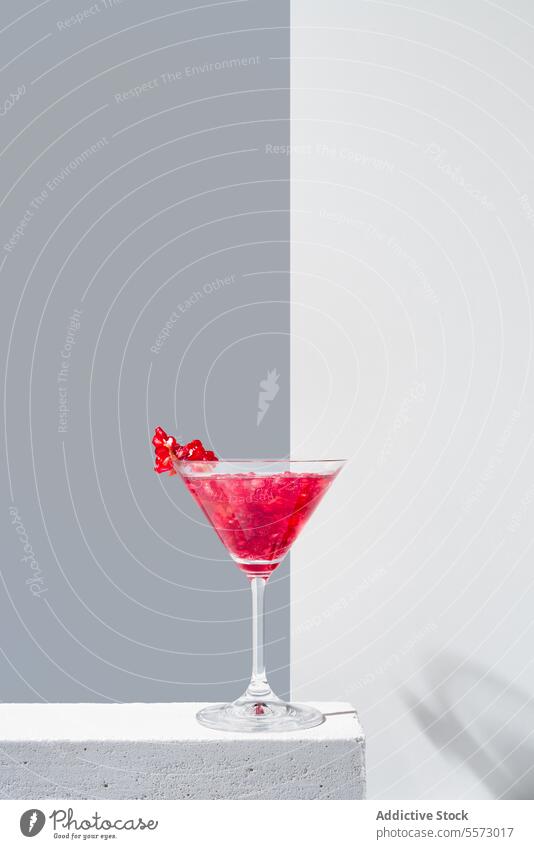 Elegant pomegranate cocktail presentation glass red garnish backdrop shadow gray vibrant beverage drink elegant decorative topping silhouette minimalistic