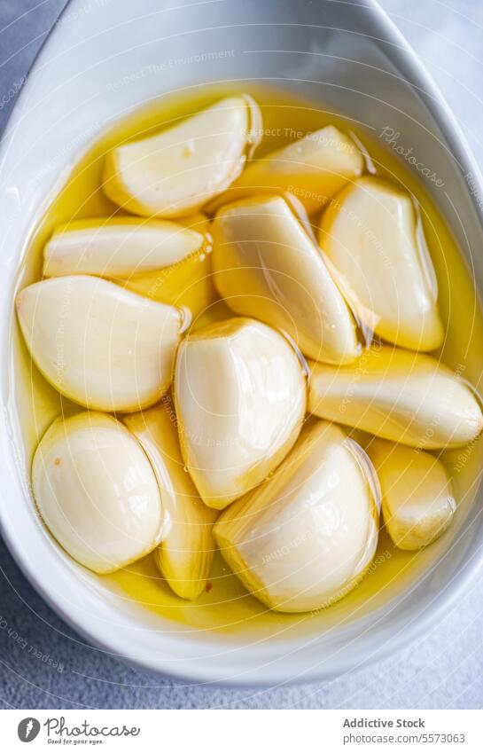 Baked organic garlic in oil on spoon clove white submerged food ingredient seasoning flavor culinary kitchen cook fresh natural preserve condiment aroma raw