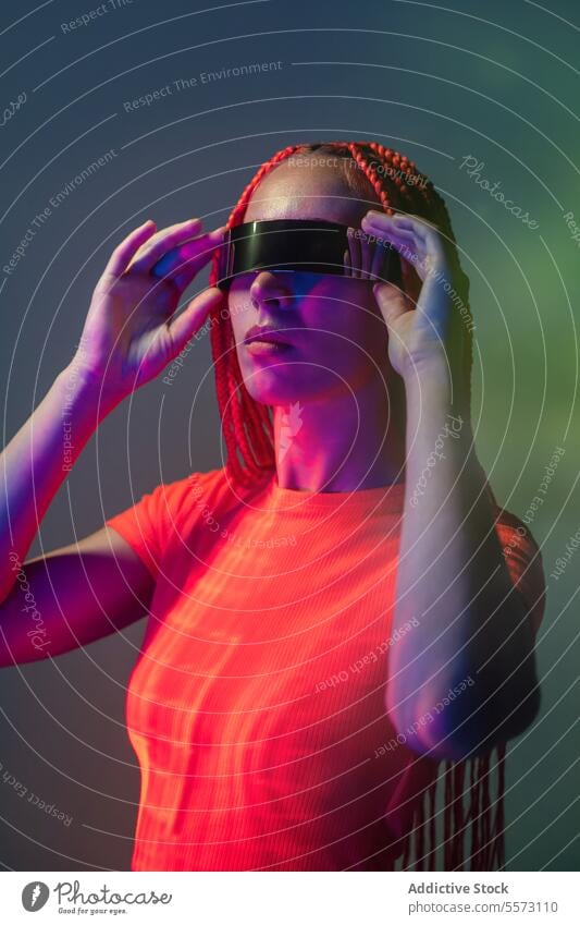 Woman in futuristic VR goggles in studio woman vr glasses experience virtual reality hairstyle studio shot light augmented cyberspace innovation simulator