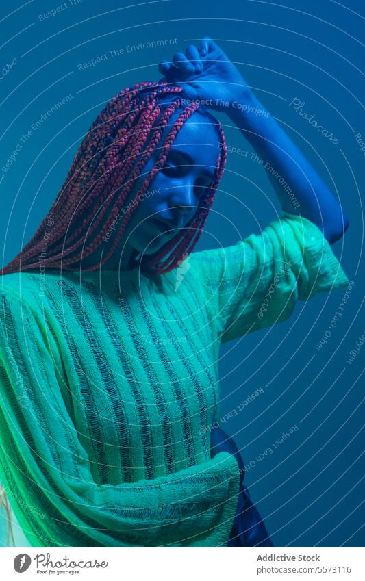 Thoughtful sad woman standing in blue light young braids contemplate serious neon glowing dreaming thinking pensive expression wonder imagine lonely solitude
