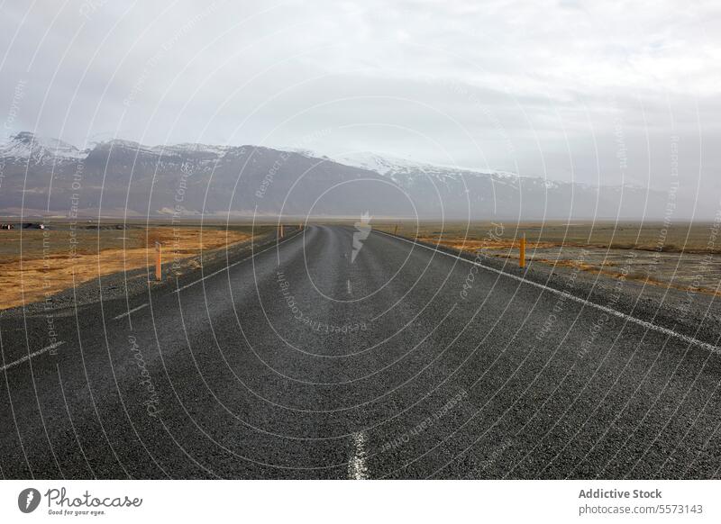 Empty asphalt road and scenic landscape with sky empty roadway marking field snow mountain travel diminishing highway destination cloud view country natural