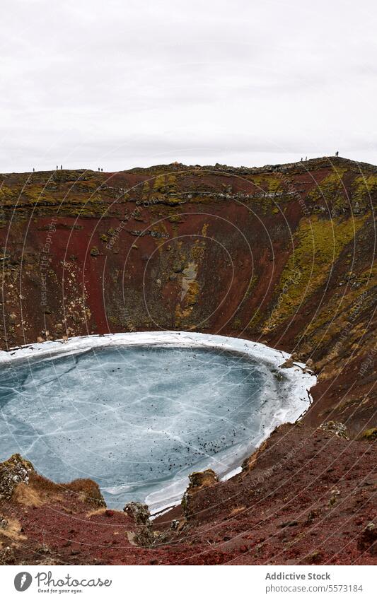 Beautiful crater with freezing lake amidst brown hilltops beautiful volcanic nature snow mountain scenic white winter cold ice calm tranquil weather season