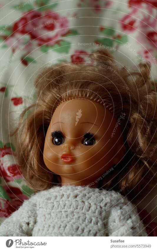 An old doll lies on a colorful pillow Doll Toys Infancy Girl Old pretty Memory Past Transience Nostalgia Family & Relations