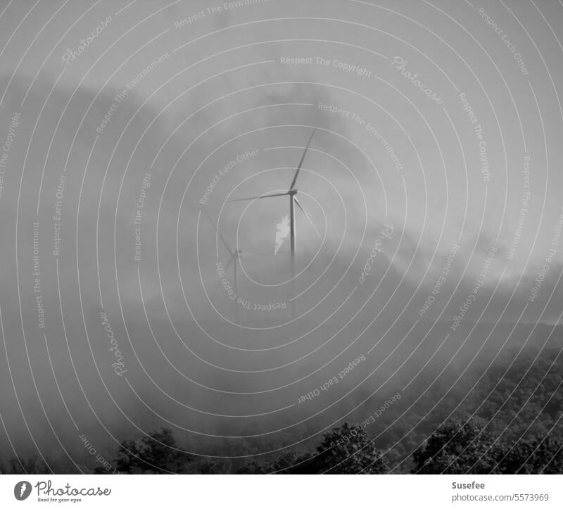 Wind turbines in the fog in black and white windmills Pinwheel Fog Clouds Sky Black & white photo Wind energy plant Energy industry Renewable energy Environment