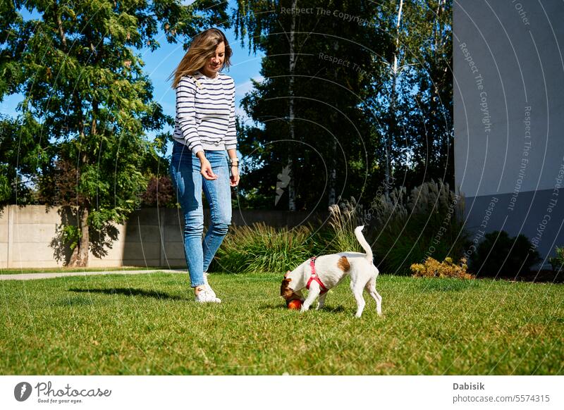 Woman walking with dog outdoors woman green trainer ball pet summer friendship nature running love animal happy lifestyle training exercise person funny field