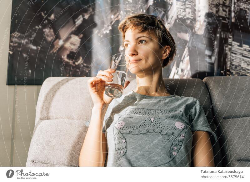 Short-haired blonde holding a glass of water woman female Domestic life people Drink person Drinking caucasian joy Glass 30-40 years Dishes Water Glass cheerful