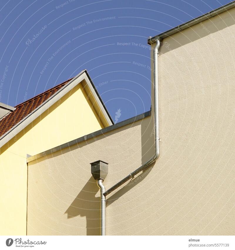 Yellow house gable and windowless rear of a house with gutter and downpipe Gable house wall dwell Eaves Downspout Apartment Building Structures and shapes