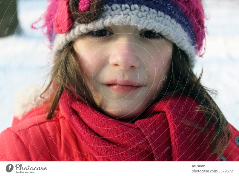 Girl with cap in winter Cap Looking into the camera Brunette frozen Cold Snow crochet hat Jacket Red brown eyes Scarf Child Infancy Human being Exterior shot