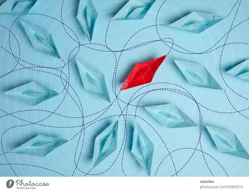 Paper boats on a blue background with paths of movement, representing the concept of individuality red paper trajectories uniqueness distinctiveness identity